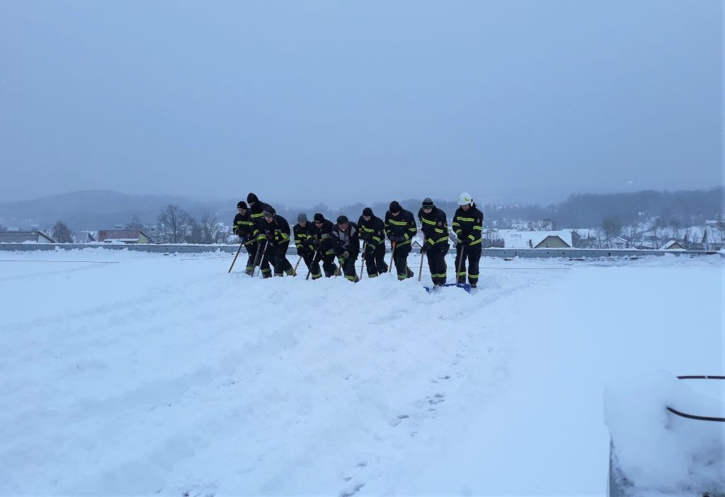 strażacy odśnieżają dach hali sportowej w Sułkowicach