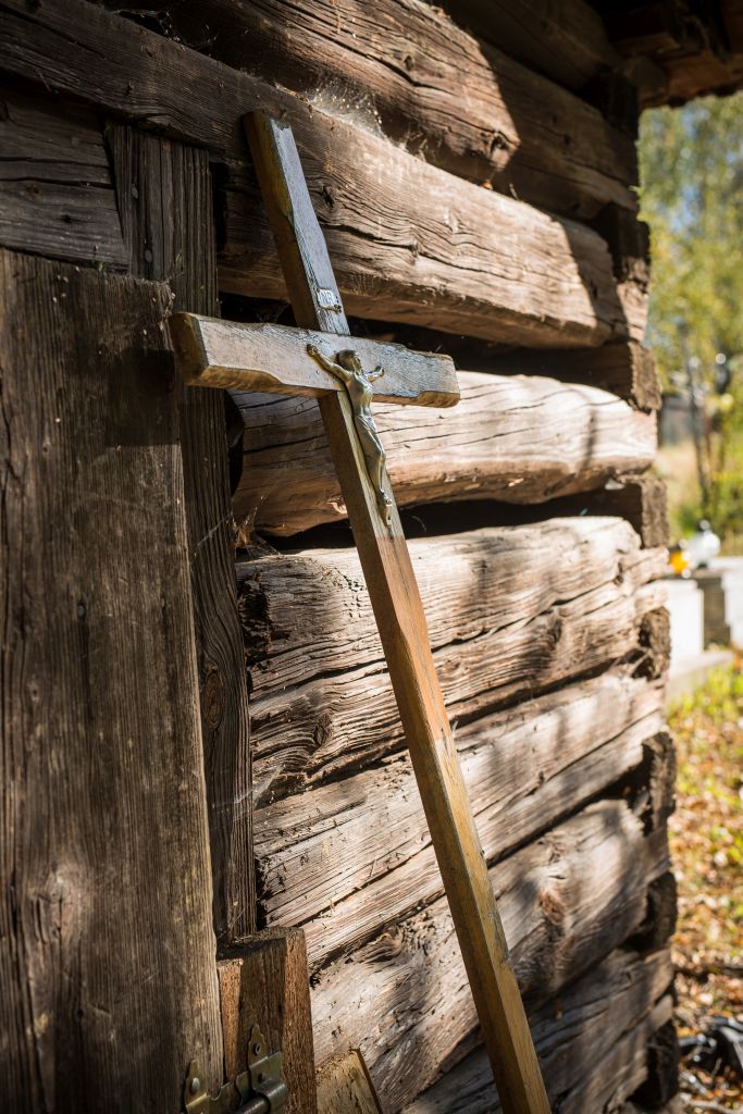 drewniany krzyż oparty o ścianę zabytkowej kostnicy